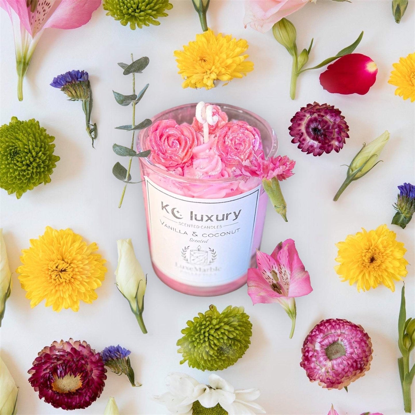 Handcrafted KC Luxe Marble Cake Candle with a marble finish and frosted elegance, surrounded by colorful flowers.