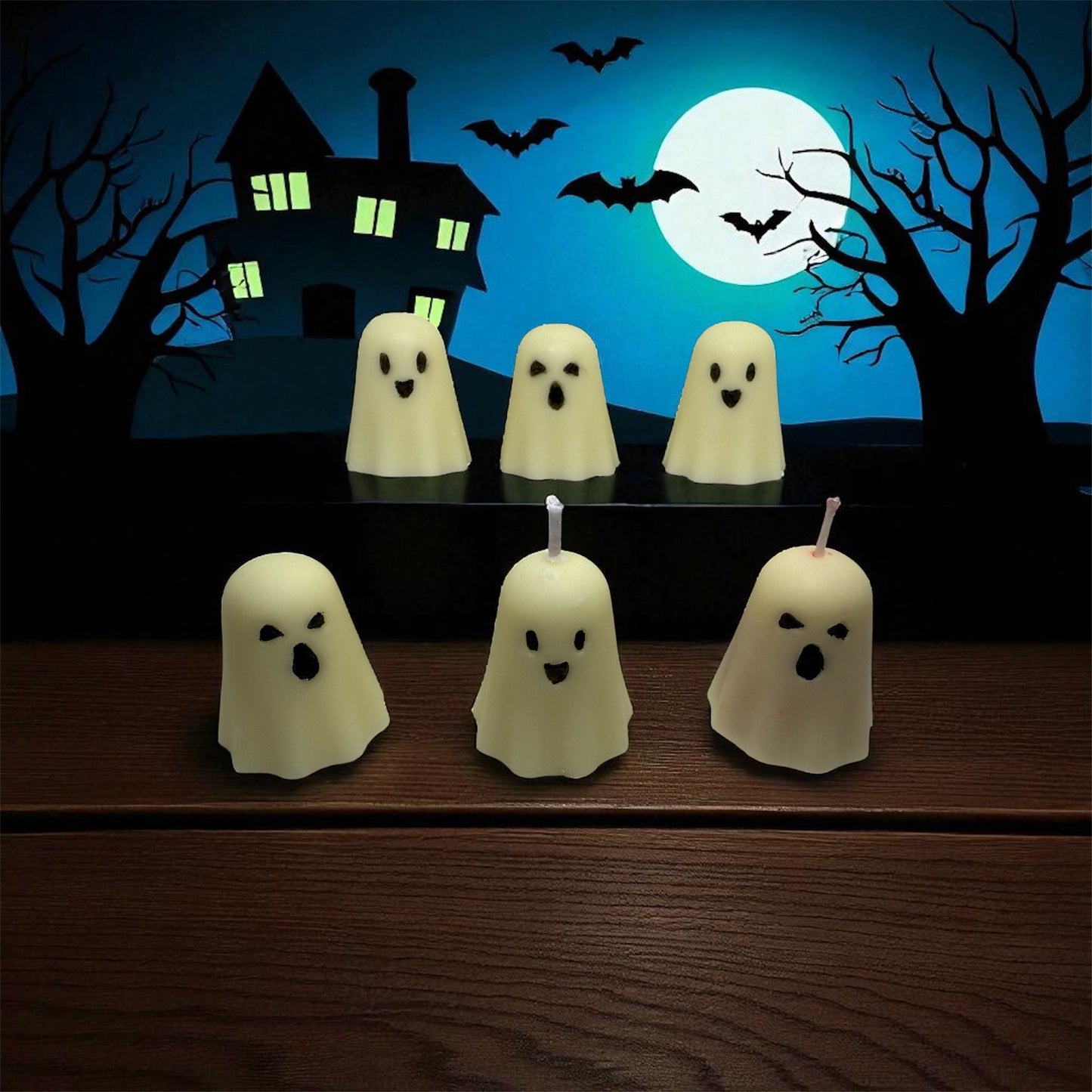 Set of six haunted ghost candles with spooky faces against a Halloween night backdrop with a full moon and bats