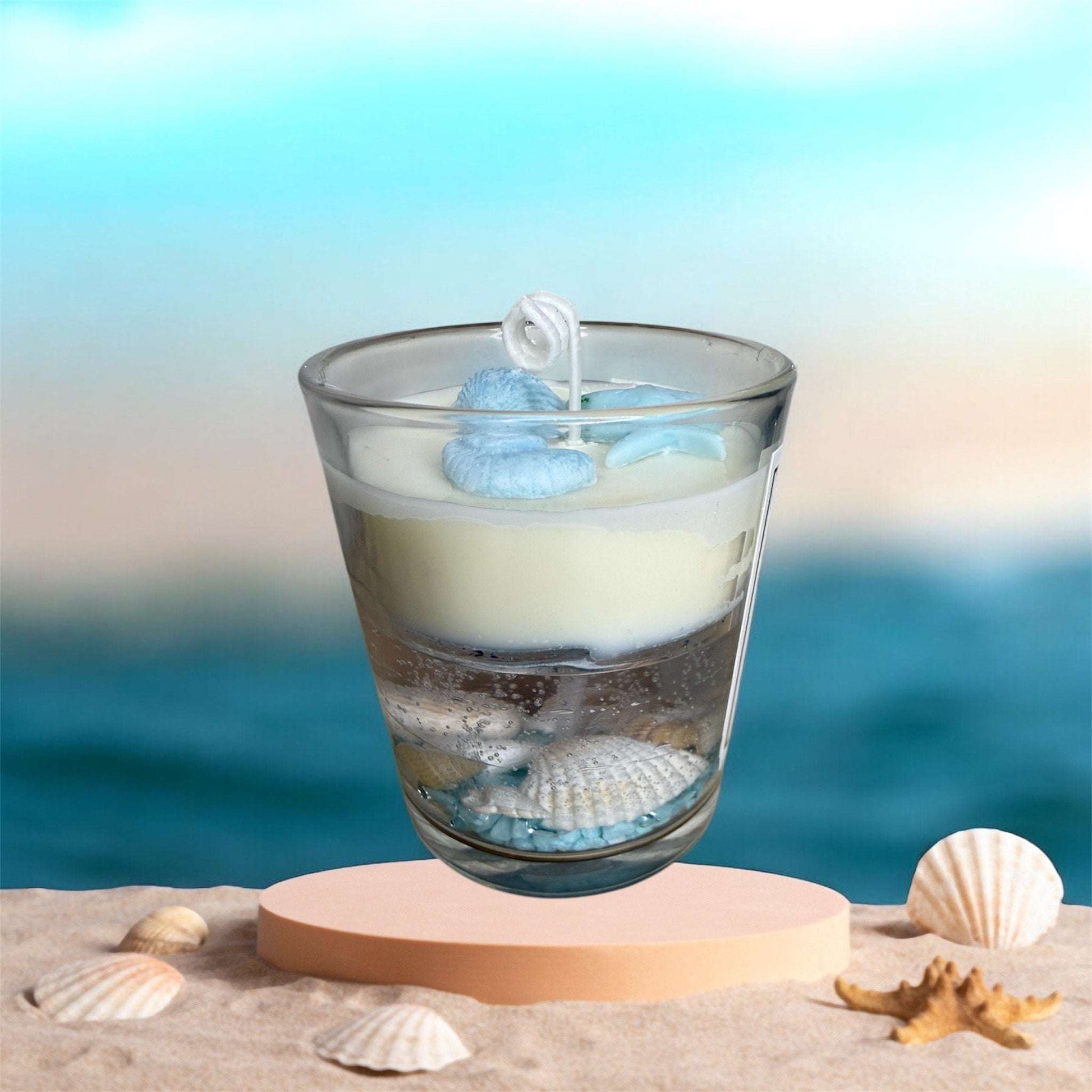 Seaglass Glow Candle from OceanLuxe Collection by KC Luxury Scented Candles on beach with ocean background.